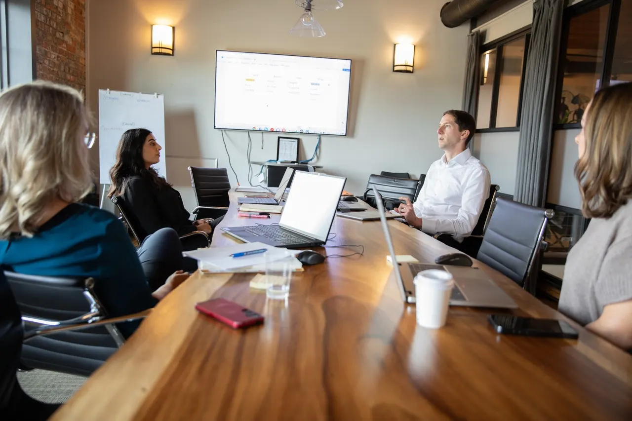The Acquen Partners team working together around a boardroom table